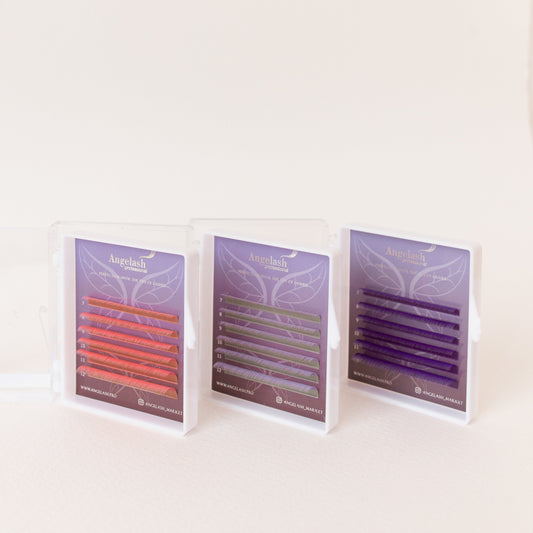Angelash red, green, and purple eyelash extension trays in cases