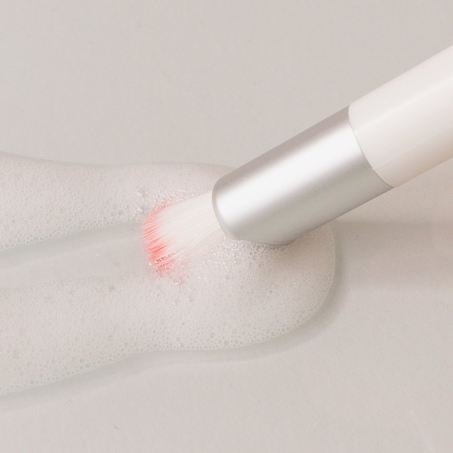 ash_cleansing_brush_with_foam_cleanser_on_surface