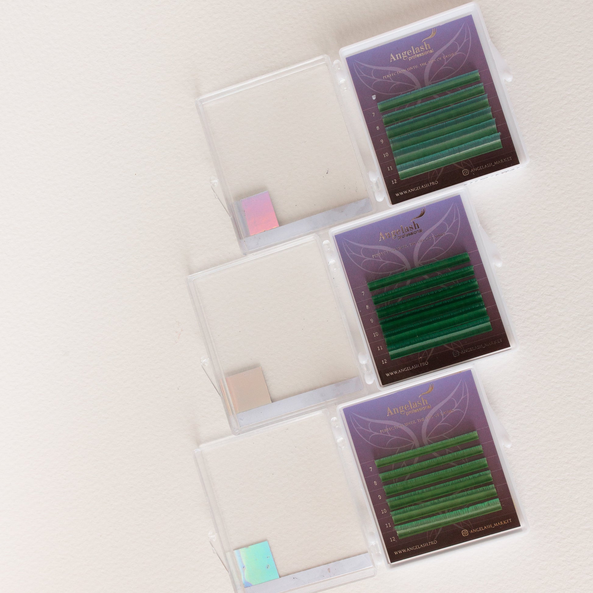 angelash_green_colored_eyelash_extension_trays_with_open_lids_on_light_background